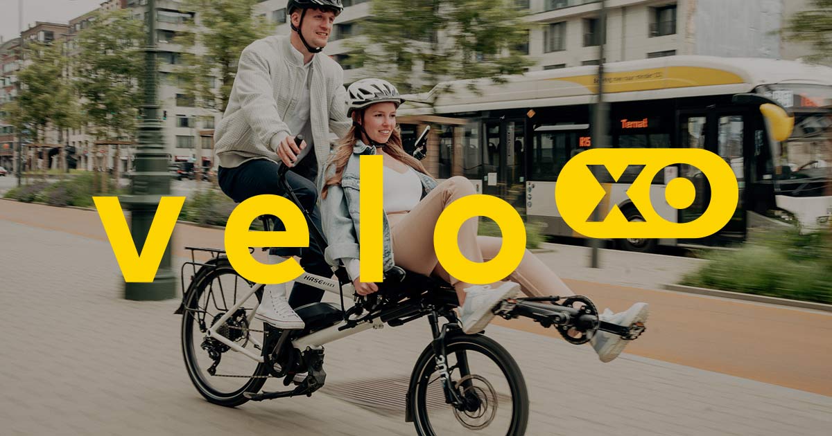 250219_social_og_image Das Logo von velo xo, im Hintergrund zwei Menschen auf dem Tandem Pino STEPS